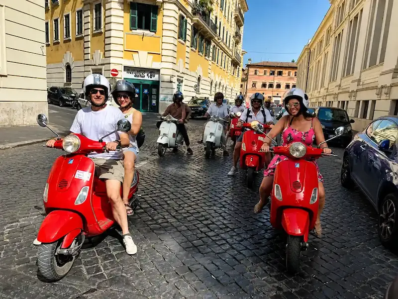 Friends riding Vespa in Rome